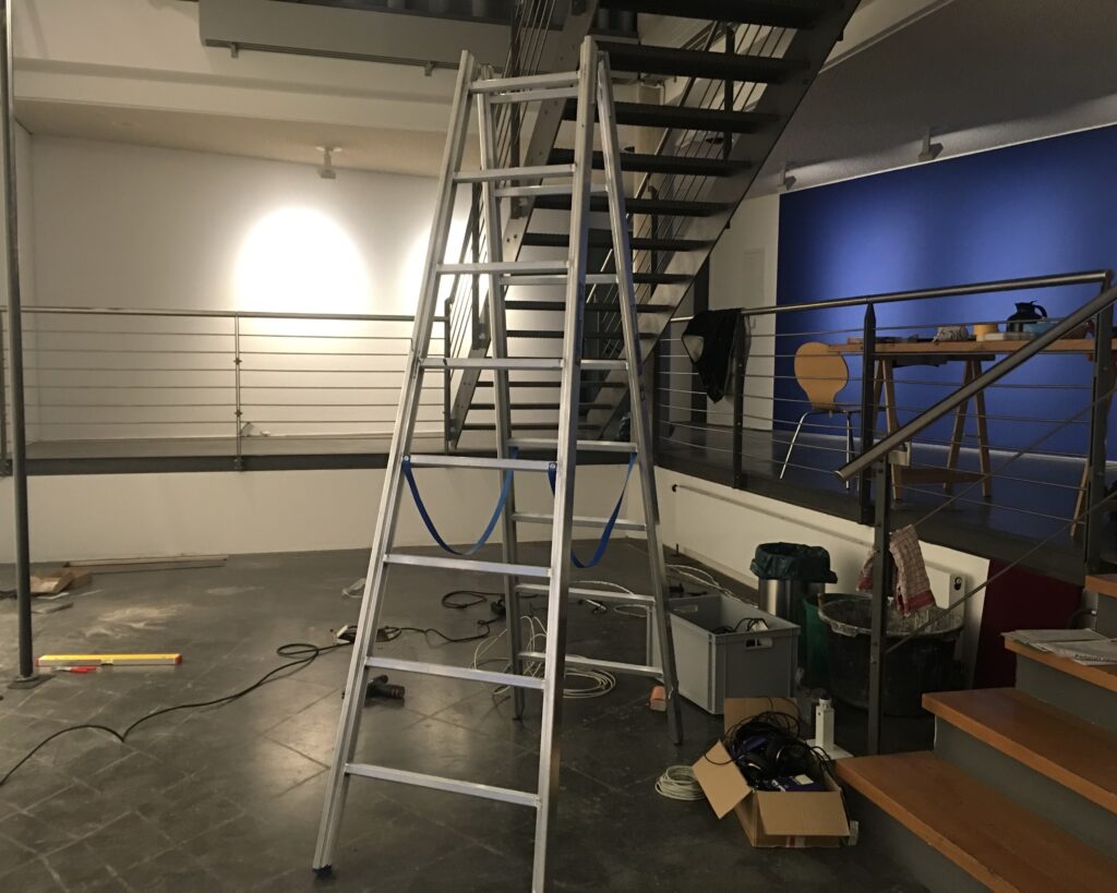 Man sieht den Ausstellungsaufbau im Haus für Medienkunst: eine Leiter und diverses Werkzeug